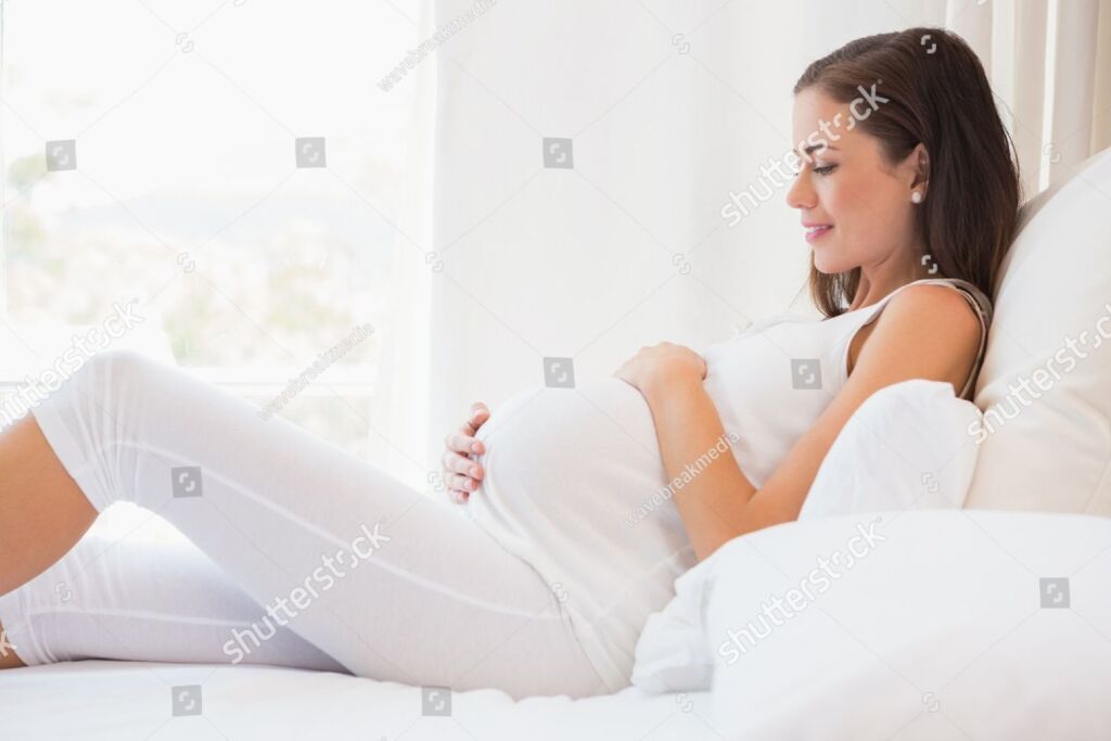 kas--stock-photo-happy-pregnancy-sitting-on-sofa-at-home-in-bedroom-292331807